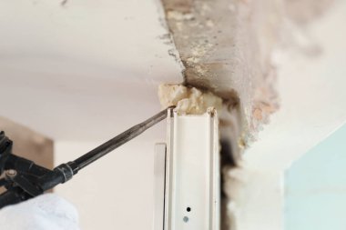 Pencere kurulumu için köpük tabanca kullanan işçiler, yakın plan