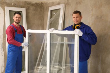 Yeni plastik pencereli üniformalı işçiler