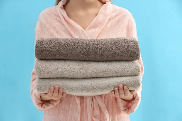 Woman Holding Stack Fresh Clean Towels Light Blue Background Closeup — Stockfoto