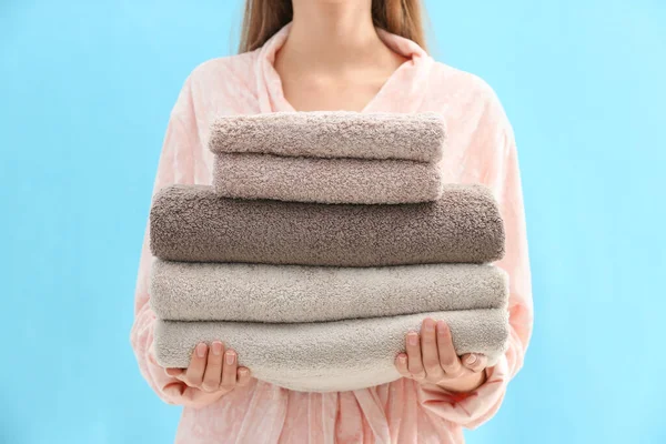 Woman Holding Stack Fresh Clean Towels Light Blue Background Closeup — Stockfoto