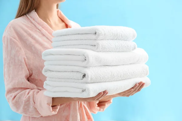 Woman Holding Stack Fresh Clean Towels Light Blue Background Closeup — Stok fotoğraf
