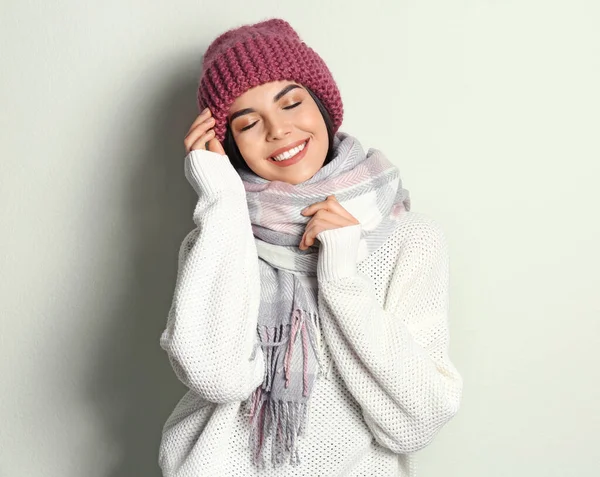 暖かいセーター スカーフ 帽子を光の背景に身に着けている若い女性 冬の季節 — ストック写真