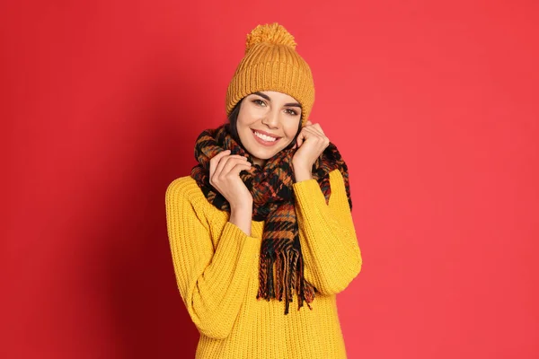 暖かいセーター スカーフ 赤い背景の帽子を身に着けている若い女性 冬の季節 — ストック写真