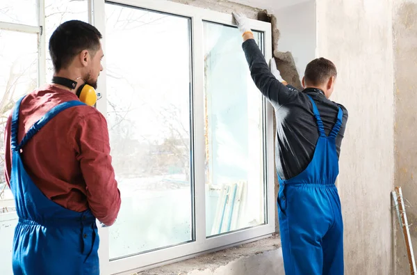 제복을 근로자들이 실내에 플라스틱 창문을 설치하는 — 스톡 사진
