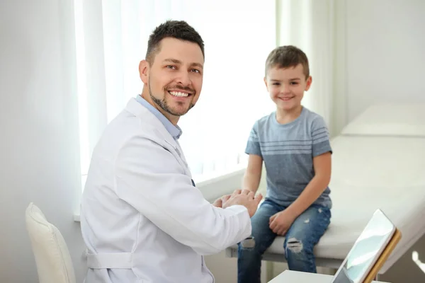 子供の医者は診療所で患者と一緒に働いている — ストック写真