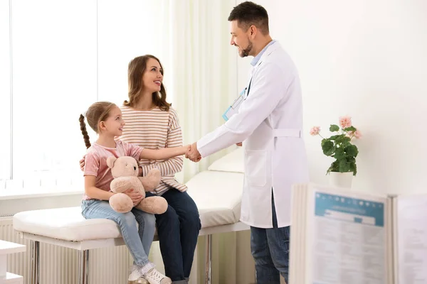 Mother and daughter visiting pediatrician. Doctor working with patient in hospital