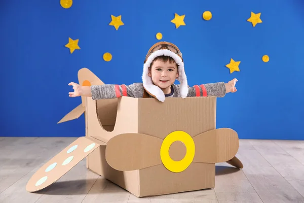 Söt Liten Barn Leker Med Kartong Flygplan Nära Blå Vägg — Stockfoto