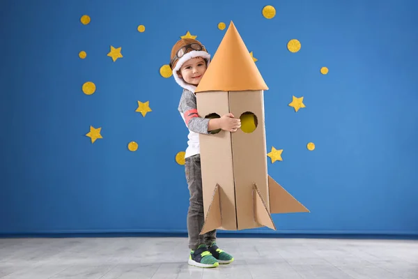 Küçük Şirin Çocuk Mavi Duvarın Yanında Karton Roketle Oynuyor — Stok fotoğraf