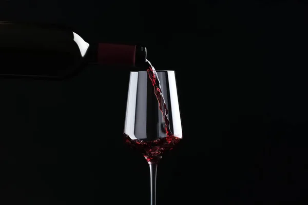 Despejar Vinho Tinto Garrafa Vidro Sobre Fundo Preto — Fotografia de Stock