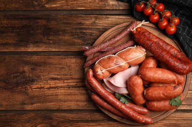 Ahşap masada farklı lezzetli sosisler, üst manzara. Metin için boşluk