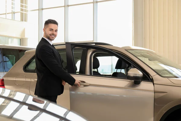 Joven Vendedor Cerca Coche Nuevo Concesionaria — Foto de Stock