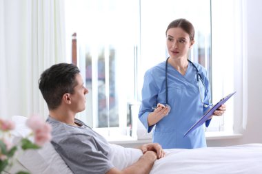 Hastane koğuşundaki hastasını ziyaret eden doktor.