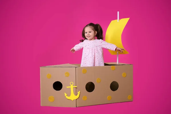 Malé Dítě Hrát Lodí Lepenkové Krabice Růžovém Pozadí — Stock fotografie
