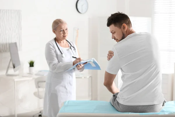 Vrouwelijke Orthopeed Die Patiënt Met Gewonde Arm Kliniek Onderzoekt — Stockfoto