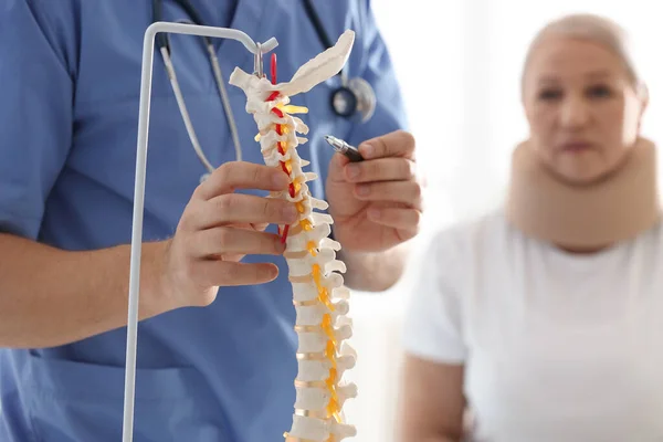 男性矫形师向病人解释脊柱结构 — 图库照片