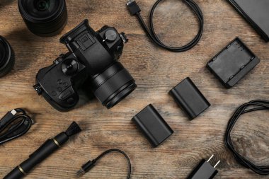 Ahşap masa üzerinde kamera ve video üretim ekipmanları ile düz kompozisyon yatıyordu