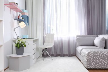 Pencerenin yanında rahat bir iş yeri olan şık bir oda. Tasarım fikri