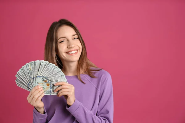 ピンクの背景にお金を持つ幸せな若い女性 テキストのスペース — ストック写真