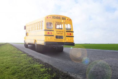 Yellow school bus on road outdoors. Transport for students