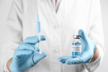 Doktor suçiçeği aşısı ve şırınga tutuyor, yakın plan. Varicella virüs önleme