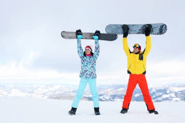 Tepede snowboard yapan sevimli bir çift. Kış tatili
