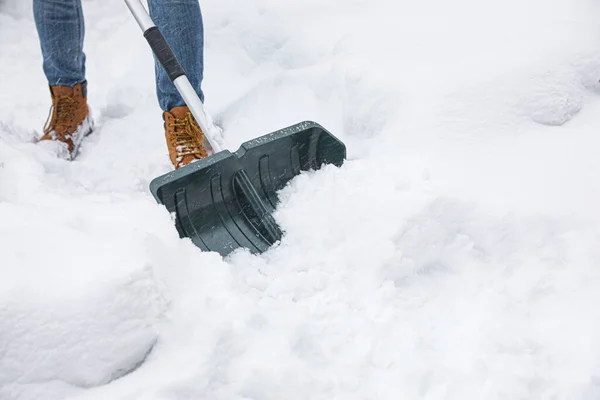 屋外のシャベルで雪を掃除する男 — ストック写真