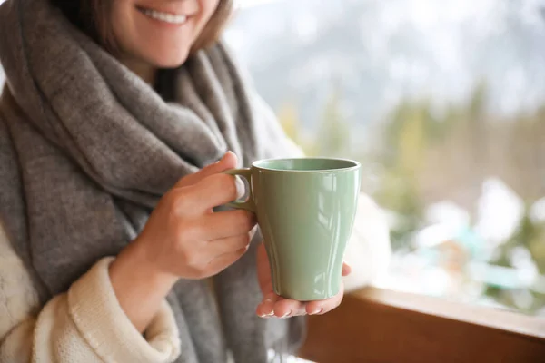 Woman with cup of tasty coffee outdoors on winter morning, closeup