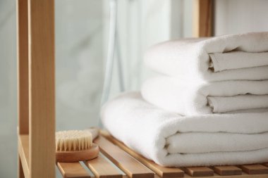 Banyonun içinde temiz havlular olan raf ünitesi.