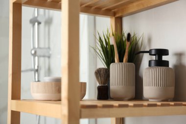 Banyo içinde tuvalet malzemeleri olan raf ünitesi.