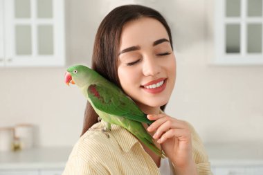 İçeride Alexandrine muhabbet kuşu olan genç bir kadın. Sevimli hayvan.