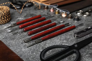 Gri taş arka planda deri örnekleri ve zanaatkar araçları