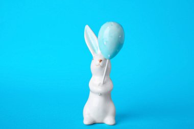 Mavi arkaplanda Paskalya dekoru olarak tavşan seramik figürü