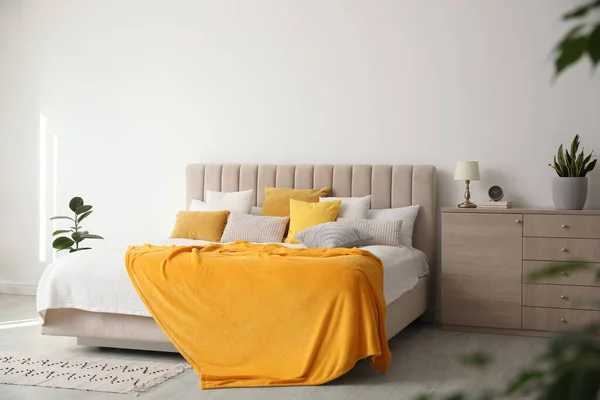 柔らかい黄色の枕と毛布とスタイリッシュなベッドルームのインテリア — ストック写真