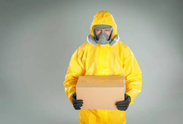 Homem Vestindo Terno Proteção Química Com Caixa Papelão Fundo Cinza — Fotografia de Stock