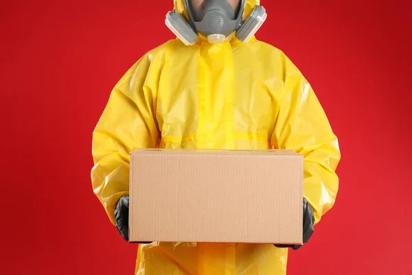 Homem Vestindo Terno Proteção Química Com Caixa Papelão Fundo Vermelho — Fotografia de Stock