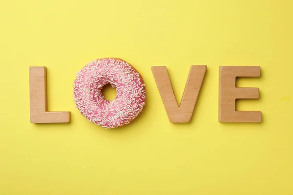 Palavra Amor Feito Com Letras Madeira Donut Fundo Amarelo Flat — Fotografia de Stock
