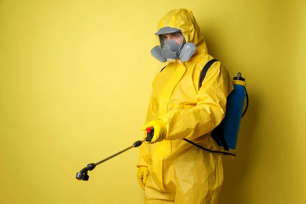 Een Man Een Beschermend Pak Met Insecticide Spray Gele Achtergrond — Stockfoto