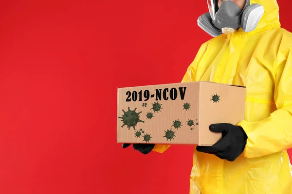 Homem Terno Proteção Química Segurando Caixa Papelão Fundo Vermelho Vista — Fotografia de Stock