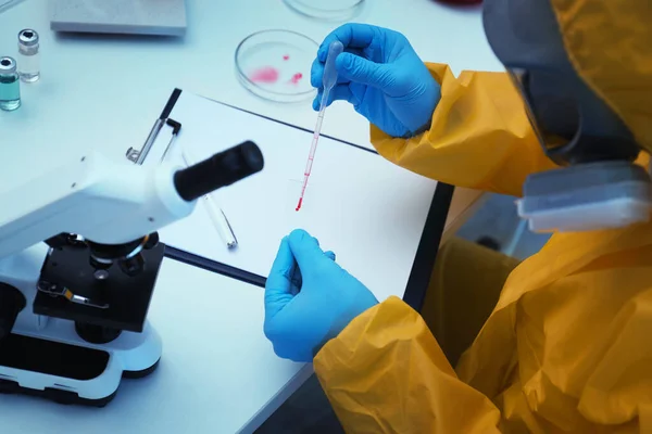 Egy Tudós Vegyi Védőruhában Vért Csöpögtet Mikroszkóp Csúszdájára Asztalnál Közelről — Stock Fotó