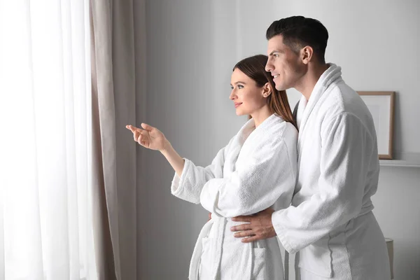 在房间窗户边穿着浴衣的快乐夫妻 — 图库照片