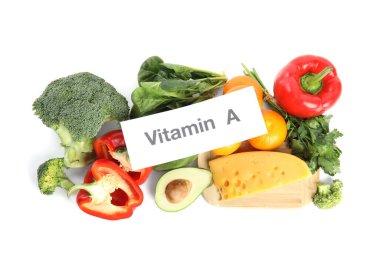 Beyaz zemin üzerinde VITAMIN A yazılı farklı doğal besin ve kağıt
