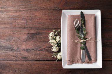 Bıldırcın yumurtaları ve ahşap arka planda çiçek dekoru olan bayramlık Paskalya sofrası. Metin için boşluk