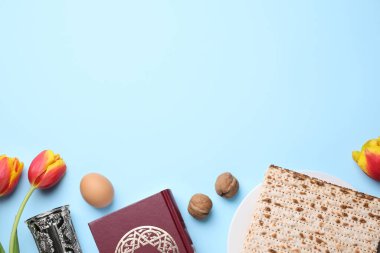 Açık mavi arkaplan üzerinde sembolik Pesach (Hamursuz Bayramı Seder) ögeleri ile düz kompozisyon, metin için boşluk