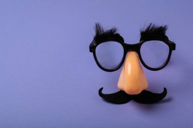 Eflatun arka planda komik parti gözlükleri, mesaj için yer. 1 Nisan 'da