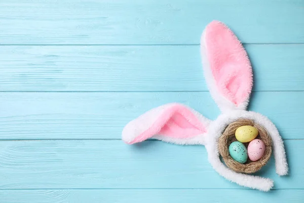 头带与兔子耳朵 彩蛋和文字空间浅蓝色的木制背景 平坦的躺 复活节假期 — 图库照片