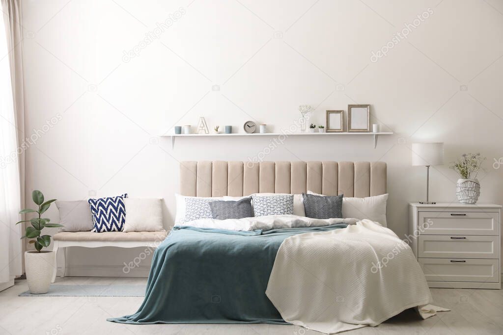 Comfortable bed with pillows in room. Stylish interior design