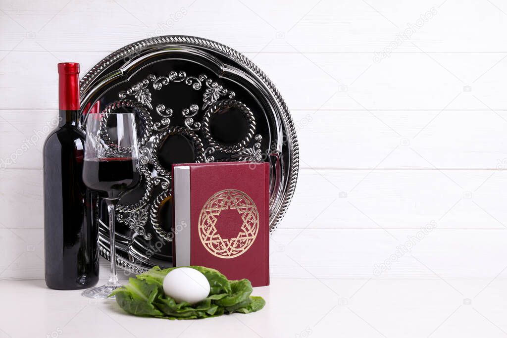 Symbolic Pesach (Passover Seder) items on white table, space for text