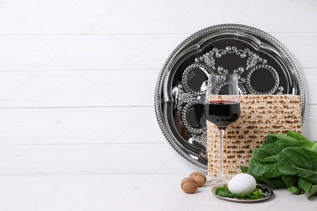 Symbolic Pesach (Passover Seder) items on white table, space for text