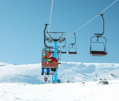 İnsanlar dağ kayak merkezindeki teleferiği kullanıyorlar. Kış tatili