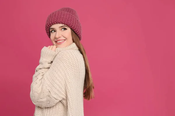 暖かいセーターと帽子を真紅の背景に身に着けている若い女性 冬の季節 — ストック写真